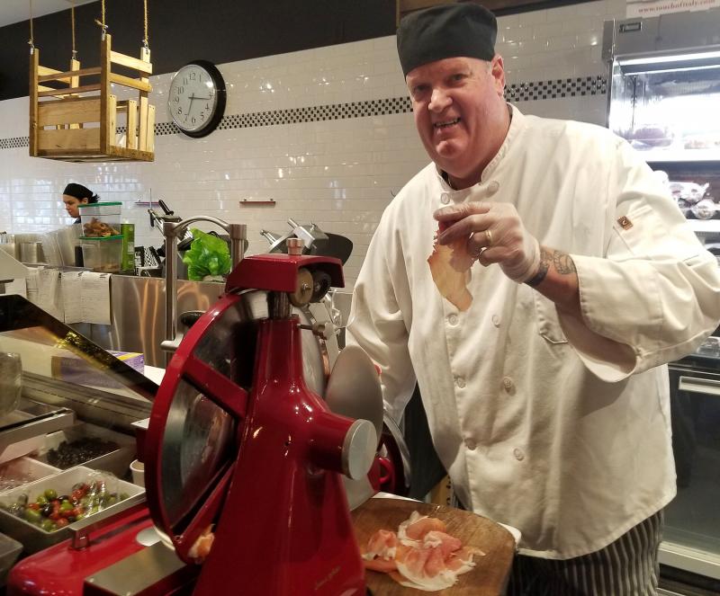 Touch of Italy's smiling deliman and catering guy "Big Ray" Perry cuts paper-thin slices of prosciutto de parma on the Big Red Slicer. BOB YESBEK PHOTOS